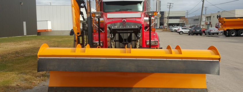 Chasse-neige rouge stationné dans une zone industrielle