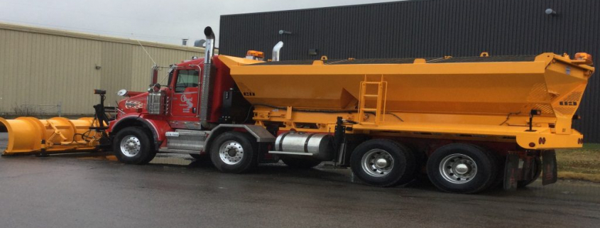 Camion de déneigement rouge et jaune stationné