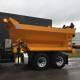 Camion de chantier jaune sur parking.