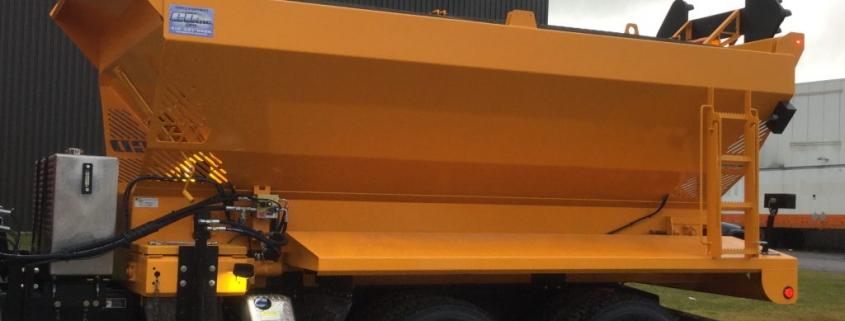 Camion de chantier jaune sur parking.