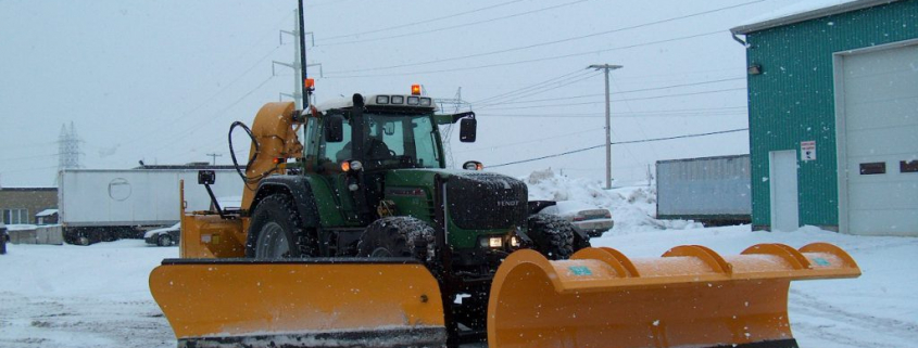 Chasse-neige dégageant la neige d'une route enneigée.