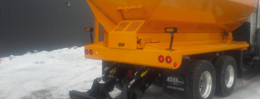 Camion d'épandage de sel sur route neigeuse